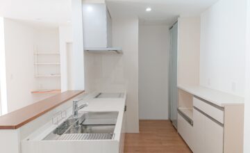白で統一された清潔感のある対面キッチン。